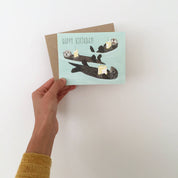 Otters Holding Cake Birthday Card